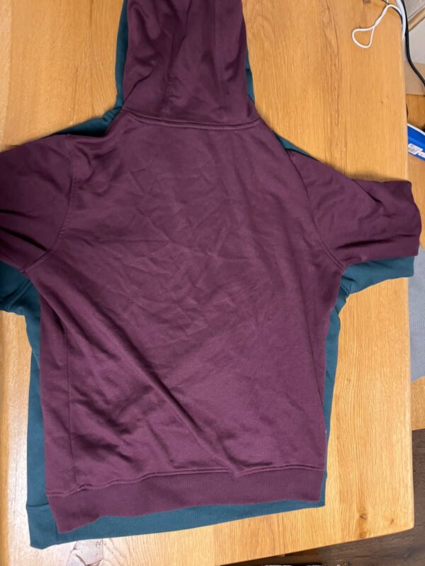Getragen und gewaschener Hoodie mit alten Schnitt (burgundy) auf ungetragenen Hoodie mit neuen Schnitt (schwarz); beide Größe L
